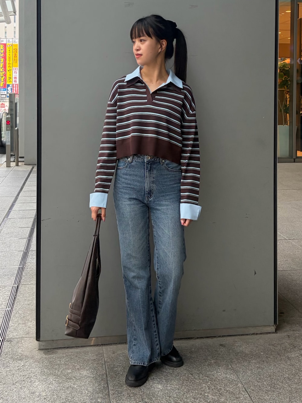 ブラウン系のニット/セーター、ブルー系のその他パンツ、ブラウン系のショルダーバッグを着用したレディースの秋コーディネートの2枚目の写真