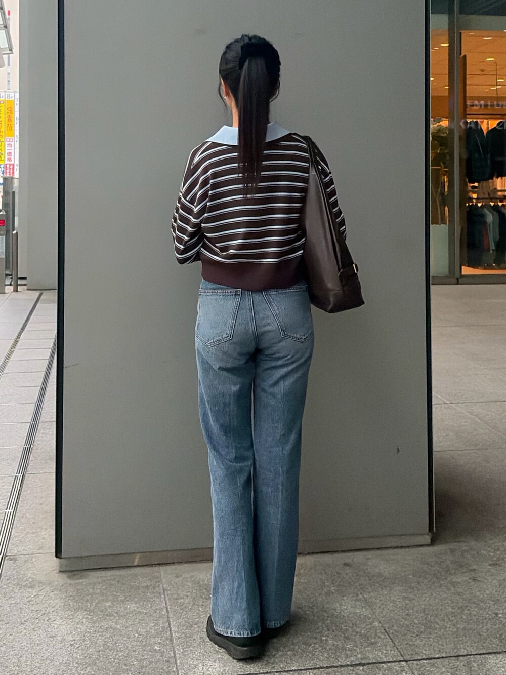 ブラウン系のニット/セーター、ブルー系のその他パンツ、ブラウン系のショルダーバッグを着用したレディースの秋コーディネートの5枚目の写真