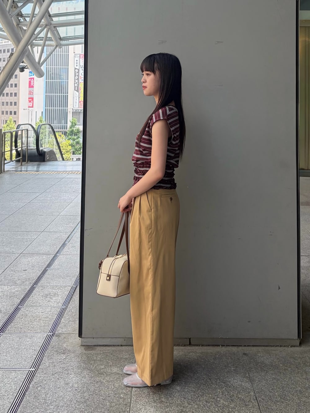 ブラウン系のTシャツ/カットソー、ベージュ系のその他パンツ、ホワイト系のボストンバッグを着用したレディースの夏コーディネートの3枚目の写真