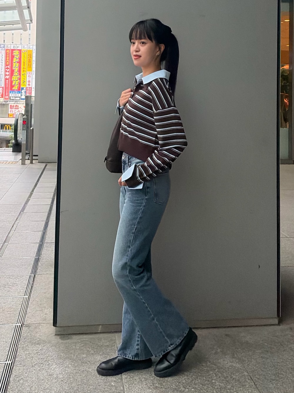 ブラウン系のニット/セーター、ブルー系のその他パンツ、ブラウン系のショルダーバッグを着用したレディースの秋コーディネートの3枚目の写真