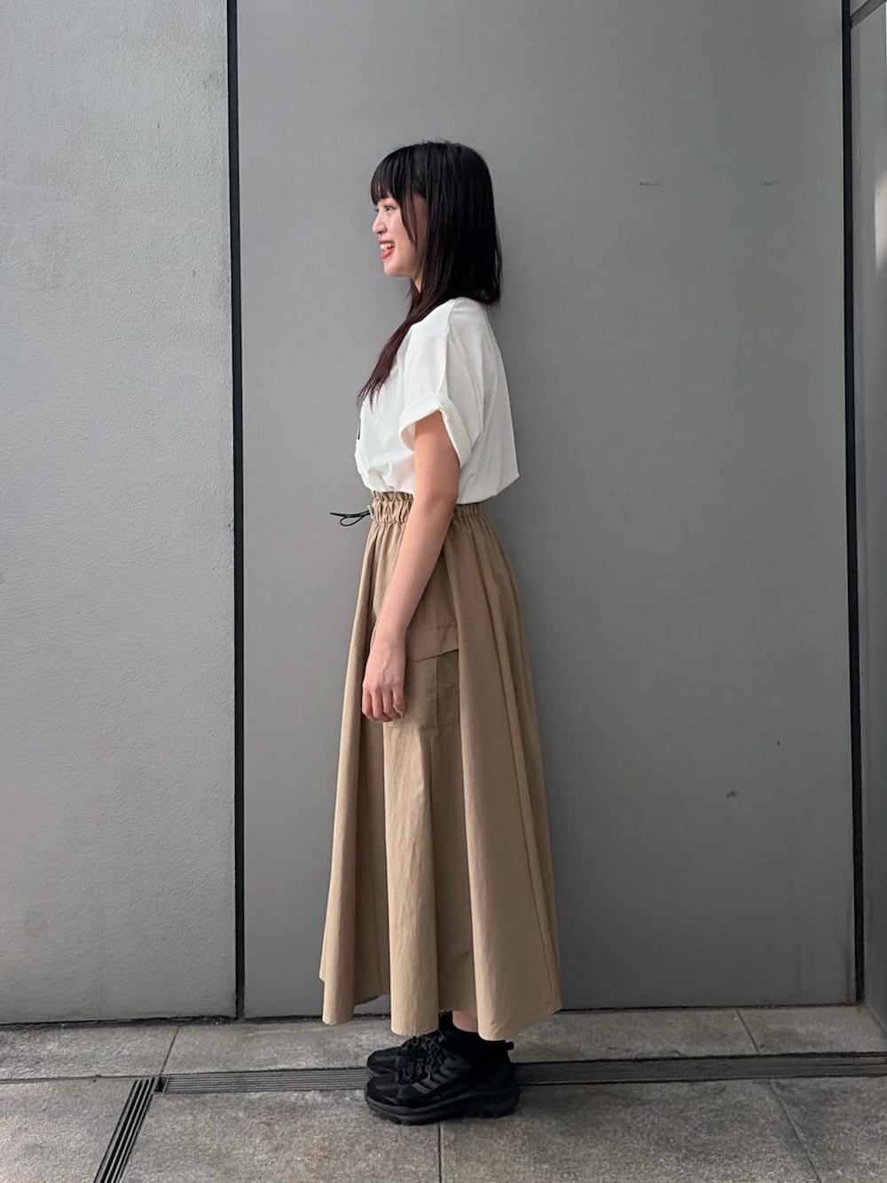 ベージュ系のスカート、ホワイト系のTシャツ/カットソーを着用したレディースの夏コーディネートの2枚目の写真