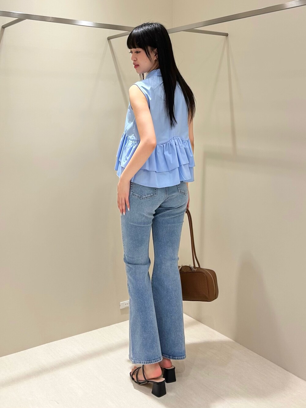 ブルー系のシャツ/ブラウス、ブルー系のデニムパンツ、ブラウン系のボストンバッグを着用したレディースの夏コーディネートの4枚目の写真