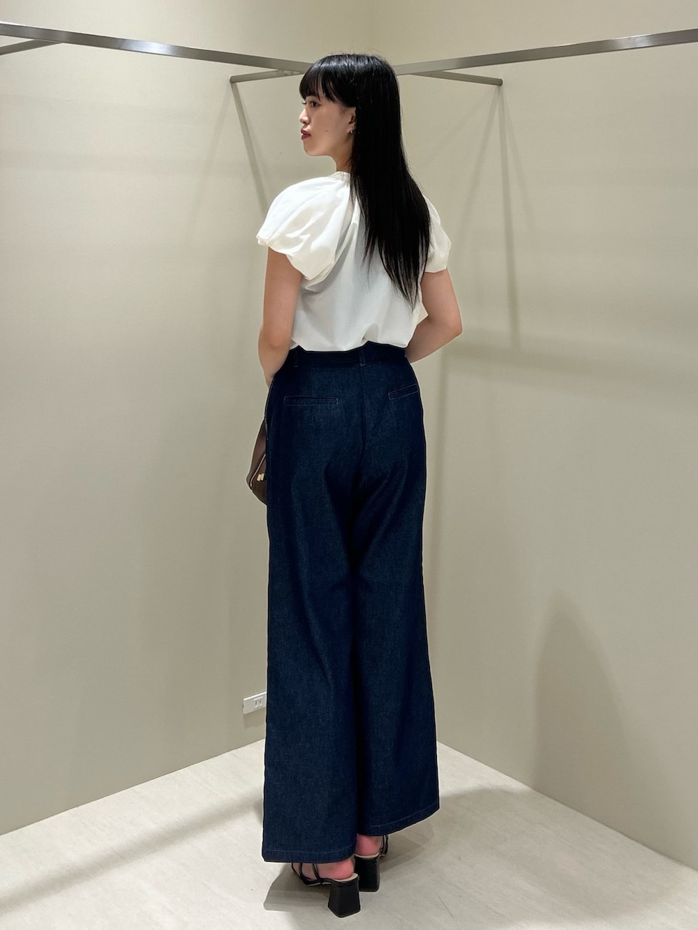 ホワイト系のシャツ/ブラウス、ブルー系のデニムパンツ、ブラック系のボストンバッグを着用したレディースの夏コーディネートの5枚目の写真