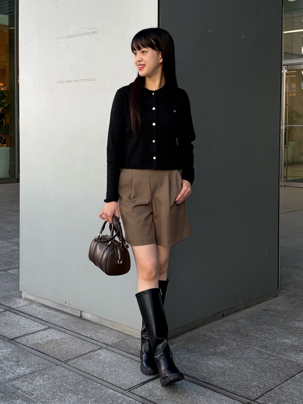 ブラック系のカーディガン/ボレロ、ブラウン系のその他パンツ、ブラウン系のボストンバッグを着用したレディースの秋コーディネートの3枚目の写真