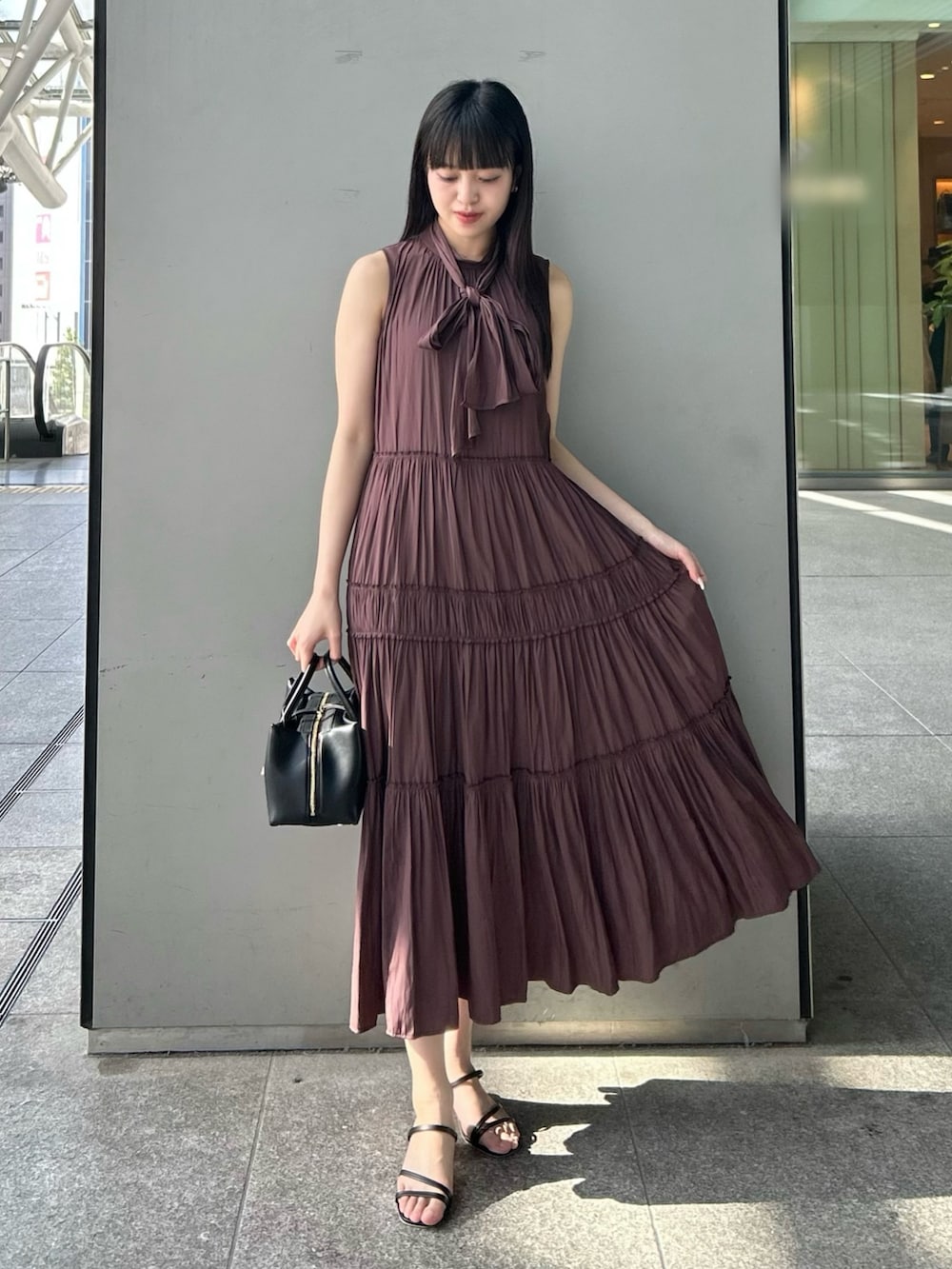 ブラウン系のワンピースを着用したレディースの夏コーディネートの3枚目の写真