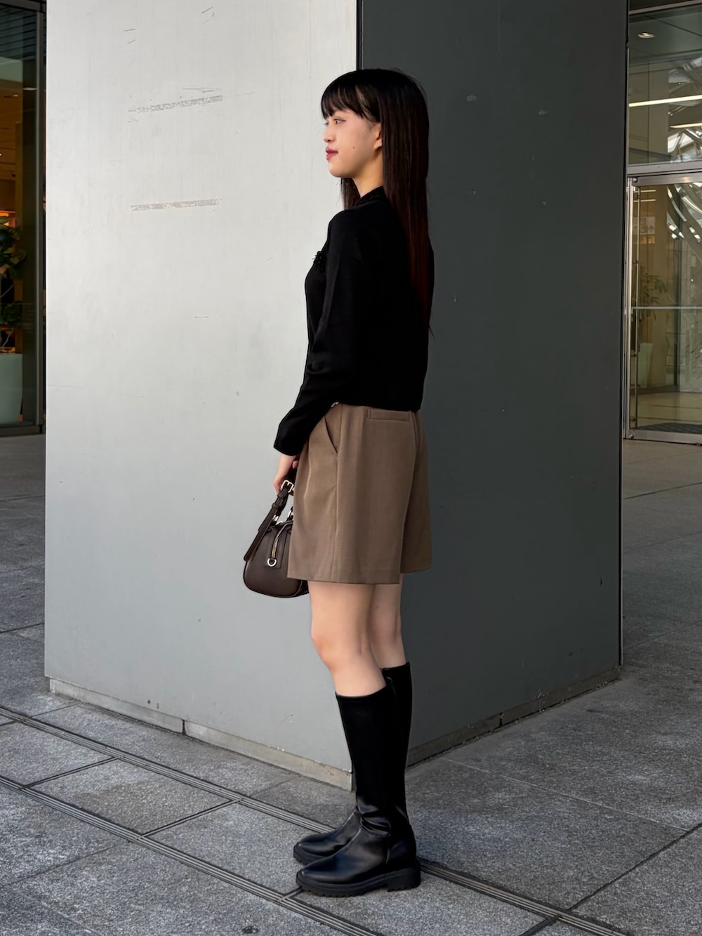 ブラック系のカーディガン/ボレロ、ブラウン系のその他パンツ、ブラウン系のボストンバッグを着用したレディースの秋コーディネートの4枚目の写真
