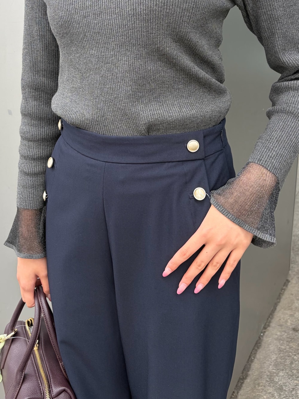グレー系のニット/セーター、ブルー系のその他パンツ、ブラウン系のボストンバッグを着用したレディースの秋コーディネートの5枚目の写真
