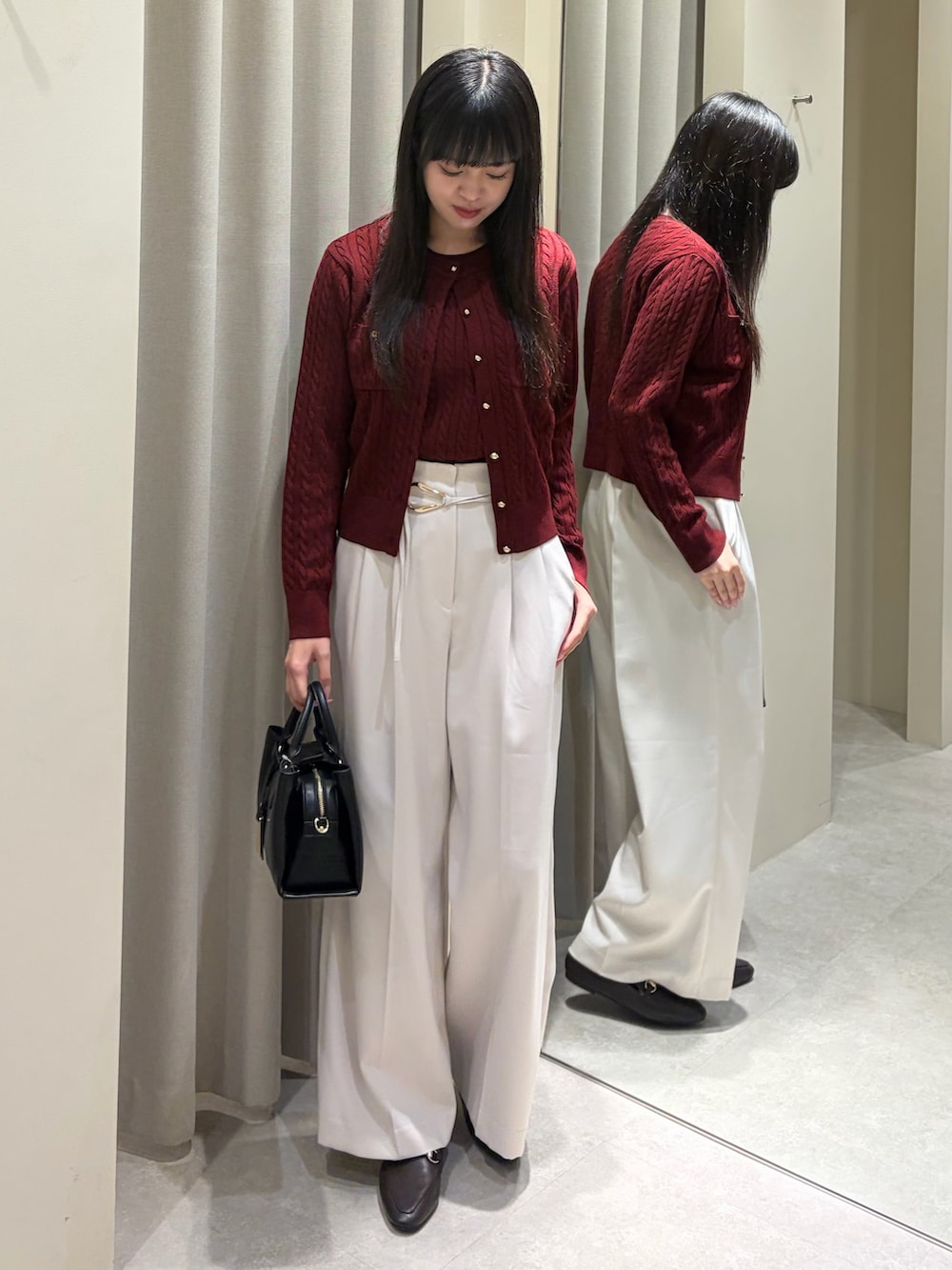 レッド系のアンサンブル、ホワイト系のその他パンツ、ブラック系のショルダーバッグを着用したレディースの秋コーディネートの2枚目の写真