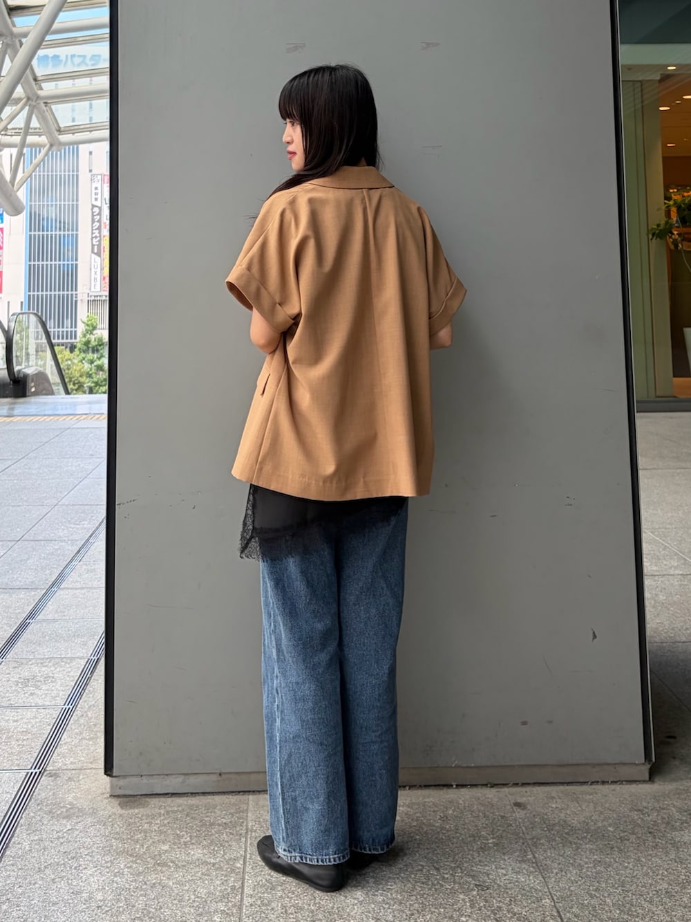 イエロー系のテーラードジャケット、ブラック系のTシャツ/カットソー、ブルー系のデニムパンツを着用したレディースの夏コーディネートの5枚目の写真