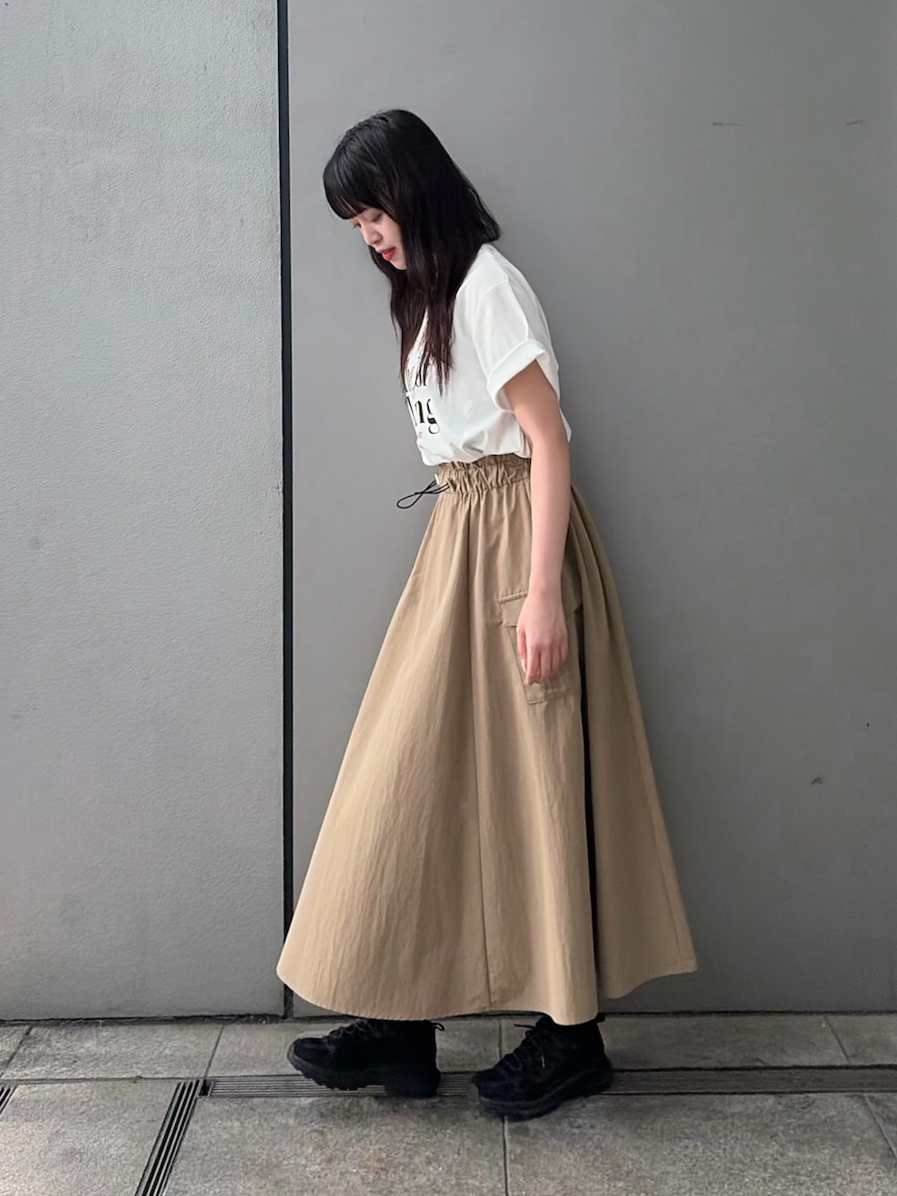 ベージュ系のスカート、ホワイト系のTシャツ/カットソーを着用したレディースの夏コーディネートの3枚目の写真