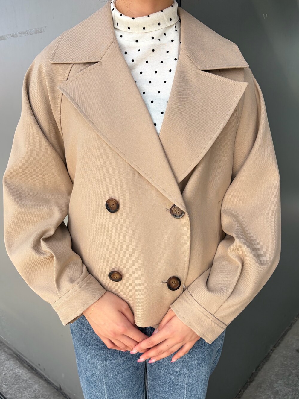 ベージュ系のトレンチコート、ブルー系のその他パンツ、ホワイト系のTシャツ/カットソーを着用したレディースの秋コーディネートの6枚目の写真