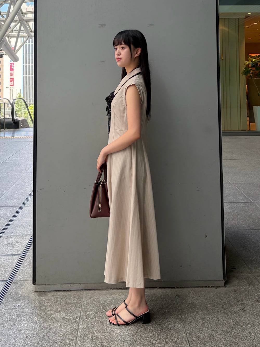 ベージュ系のワンピース、レッド系のトートバッグを着用したレディースの夏コーディネートの3枚目の写真