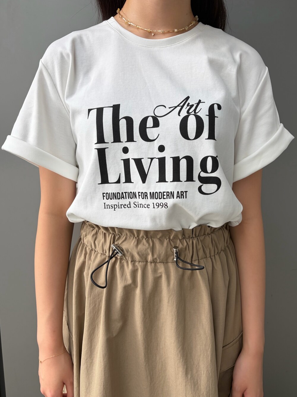 ベージュ系のスカート、ホワイト系のTシャツ/カットソーを着用したレディースの夏コーディネートの5枚目の写真