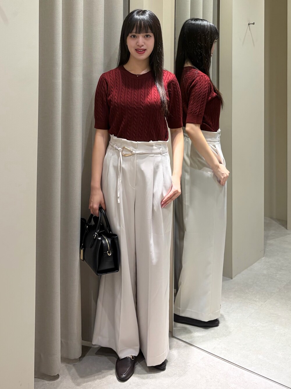 レッド系のアンサンブル、ホワイト系のその他パンツ、ブラック系のショルダーバッグを着用したレディースの秋コーディネートの3枚目の写真