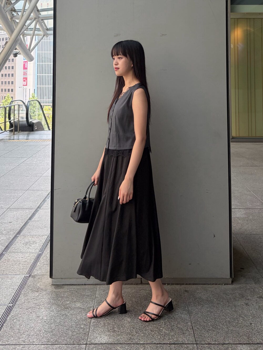 グレー系のワンピース、ブラック系のボストンバッグを着用したレディースの夏コーディネートの3枚目の写真