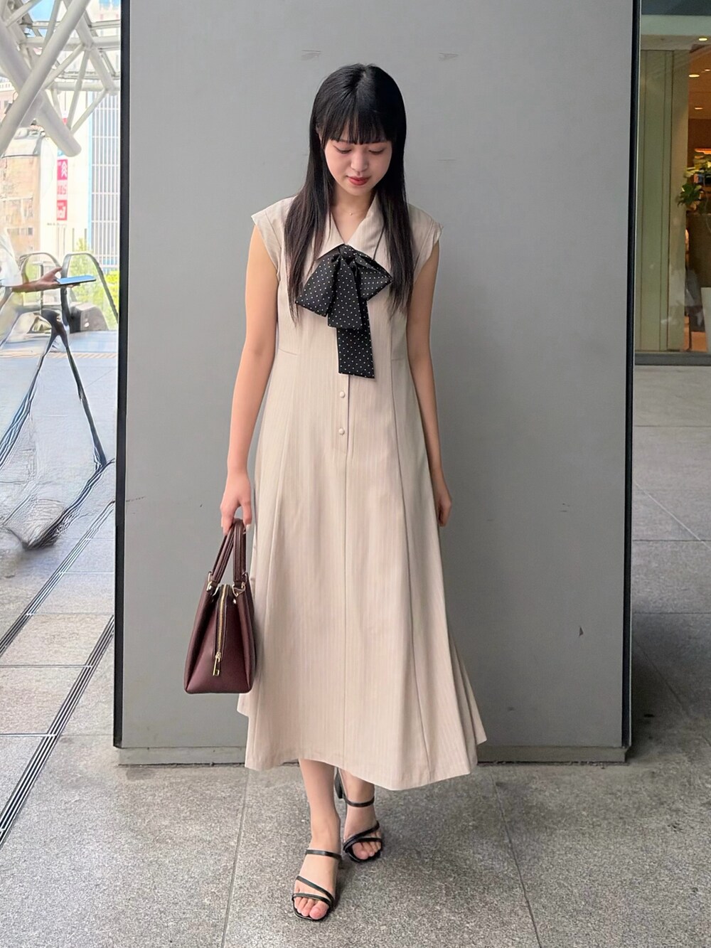 ベージュ系のワンピース、レッド系のトートバッグを着用したレディースの夏コーディネートの2枚目の写真