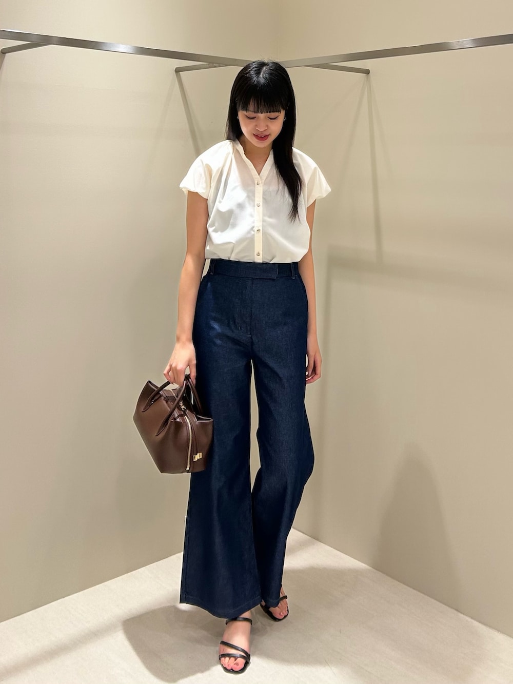 ホワイト系のシャツ/ブラウス、ブルー系のデニムパンツ、ブラック系のボストンバッグを着用したレディースの夏コーディネートの3枚目の写真