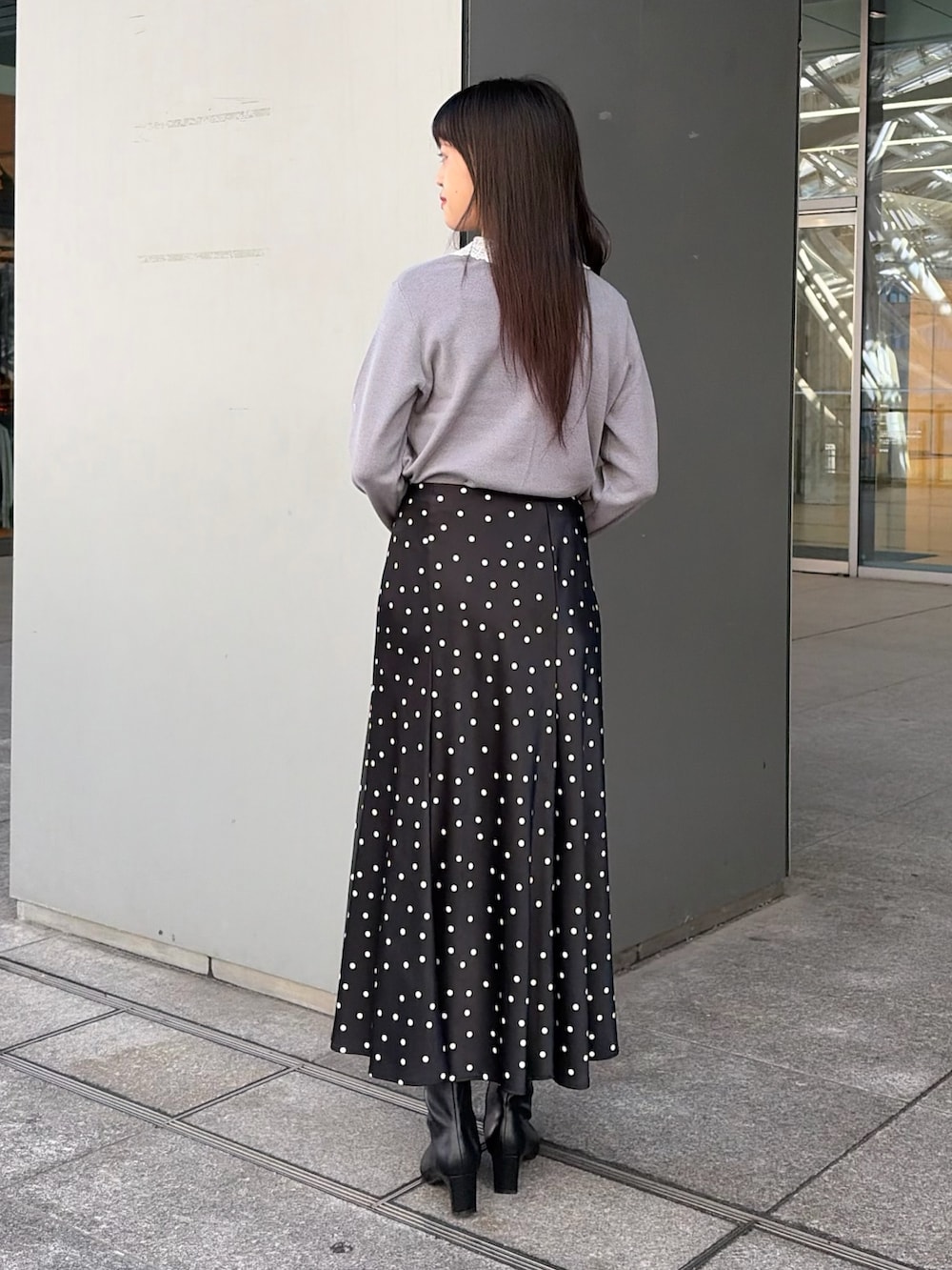 グレー系のカーディガン/ボレロ、ブラック系のスカート、レッド系のトートバッグを着用したレディースの秋コーディネートの5枚目の写真