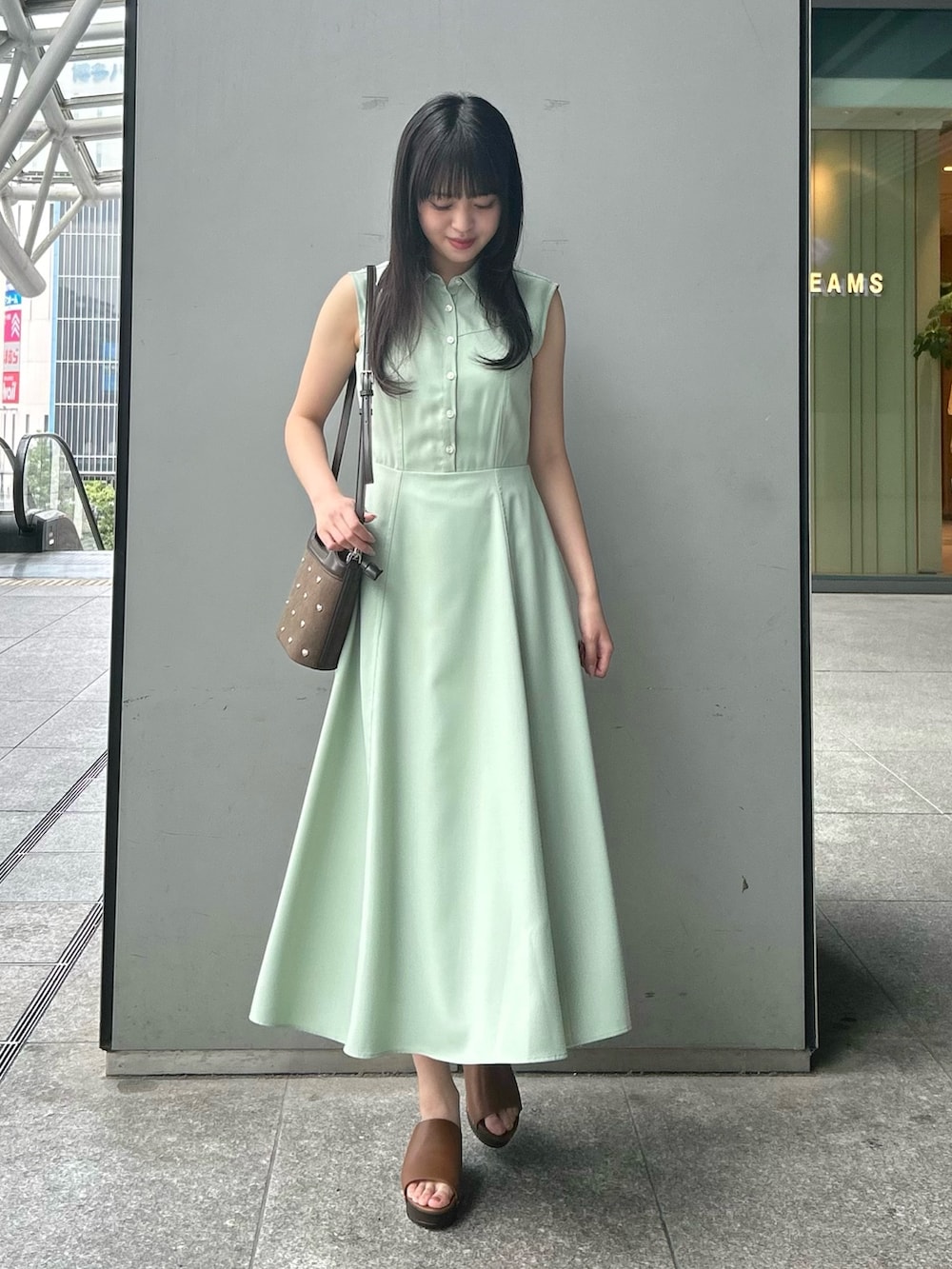 グリーン系のワンピース、ブラウン系のショルダーバッグ、イエロー系のサンダルを着用したレディースの夏コーディネートの3枚目の写真