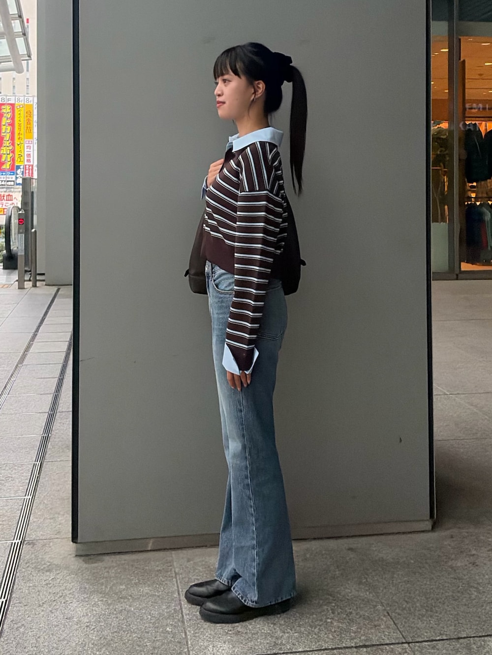 ブラウン系のニット/セーター、ブルー系のその他パンツ、ブラウン系のショルダーバッグを着用したレディースの秋コーディネートの4枚目の写真