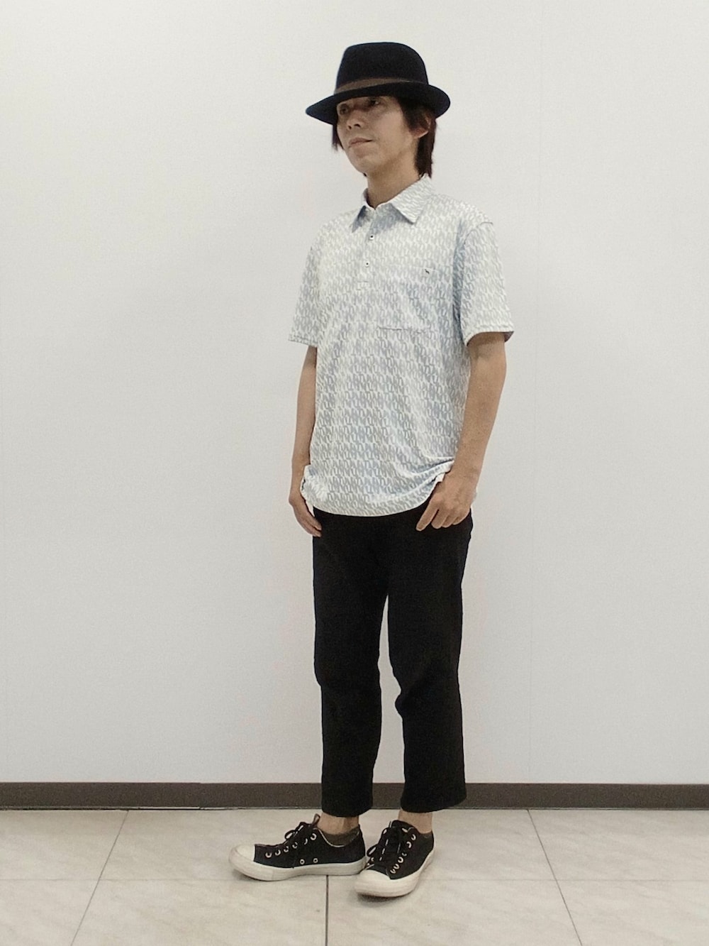グレー系のポロシャツ、ブラック系のその他パンツを着用したメンズの夏コーディネートの4枚目の写真