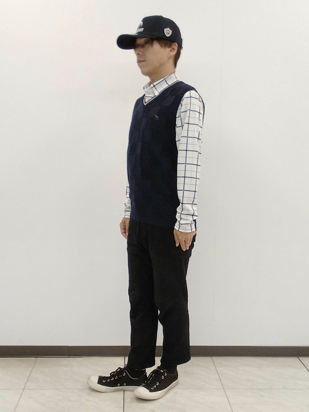 ホワイト系のポロシャツ、ブラウン系のその他パンツ、ブルー系のキャップを着用したメンズの秋コーディネートの5枚目の写真