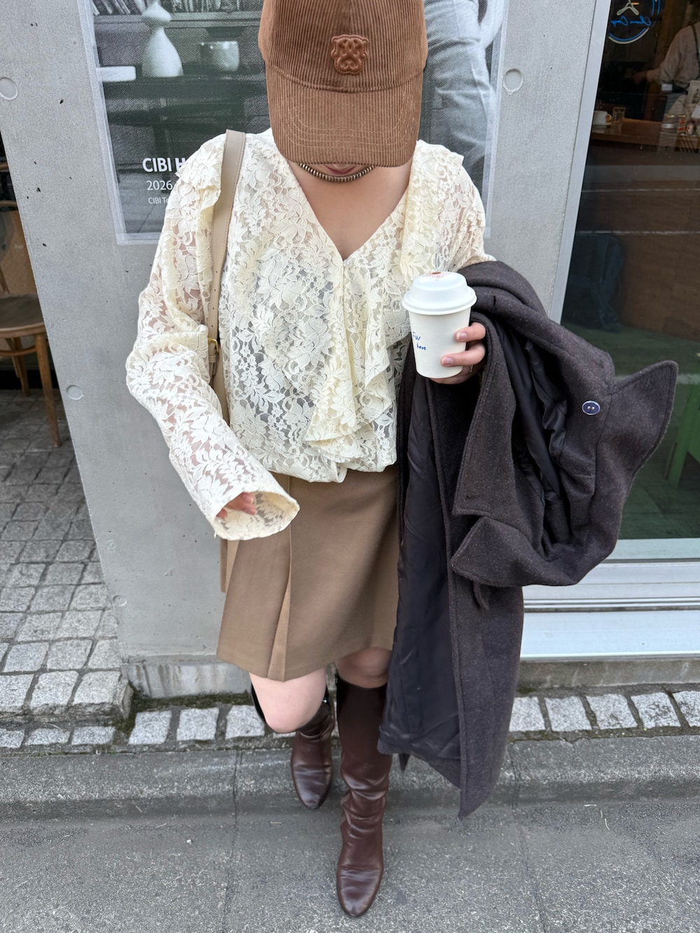 ベージュ系のシャツ/ブラウス、ベージュ系のスカート、ブラウン系の帽子を着用したレディースの冬コーディネートの5枚目の写真