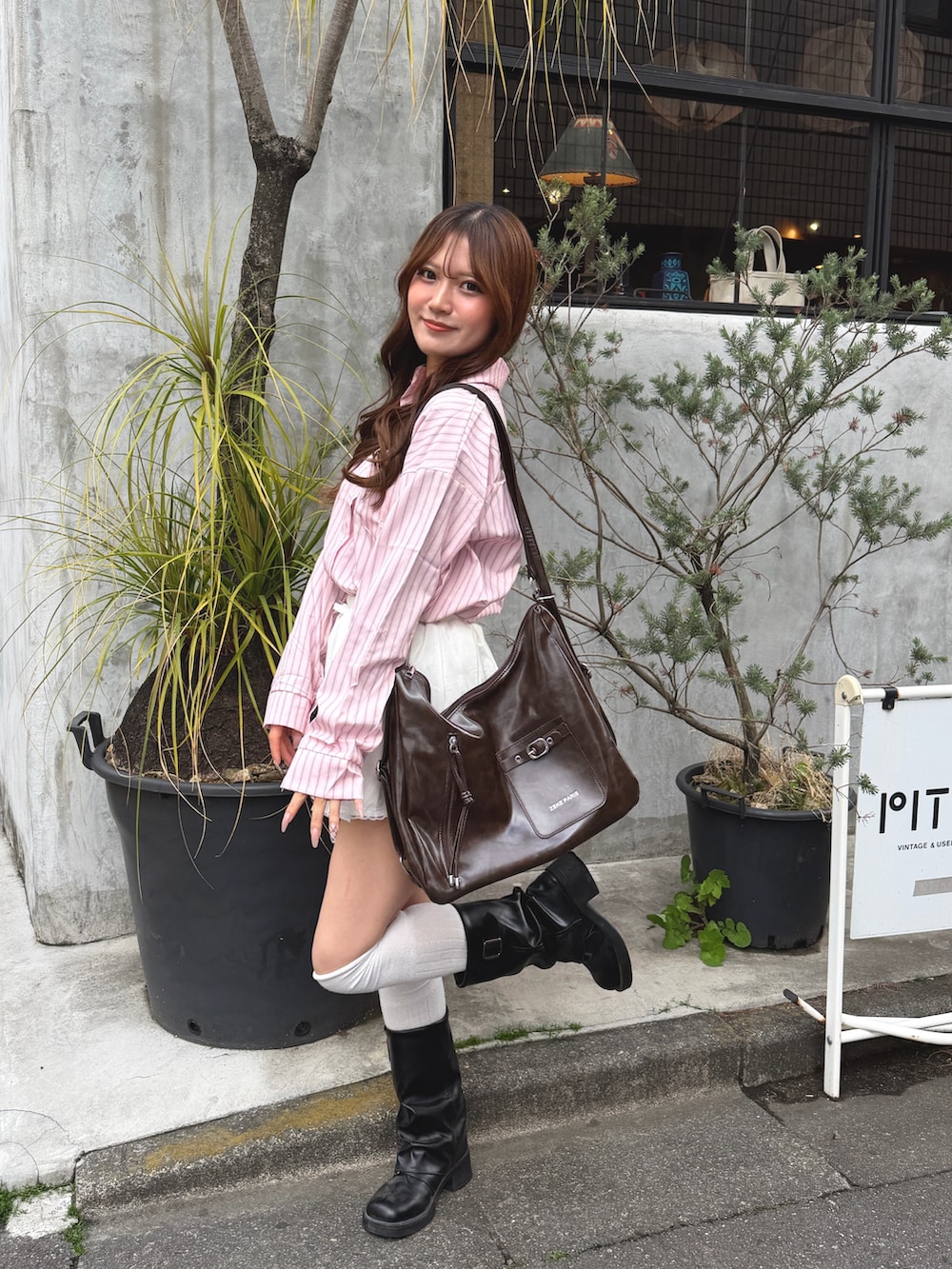 ピンク系のシャツ/ブラウス、ブラウン系のショルダーバッグを着用したレディースの春コーディネートの3枚目の写真