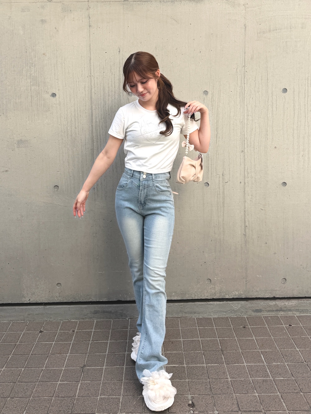 ピンク系のショルダーバッグ、ホワイト系のTシャツ/カットソー、ブルー系のデニムパンツを着用したレディースの春コーディネートの2枚目の写真