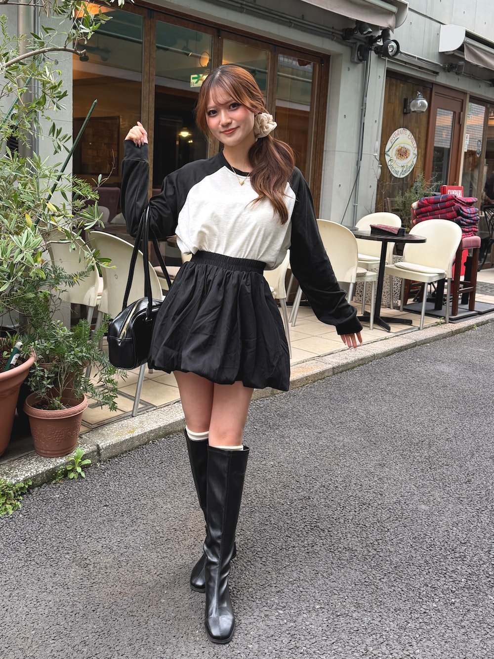 ブラック系のボストンバッグ、ブラック系のTシャツ/カットソーを着用したレディースの春コーディネートの2枚目の写真