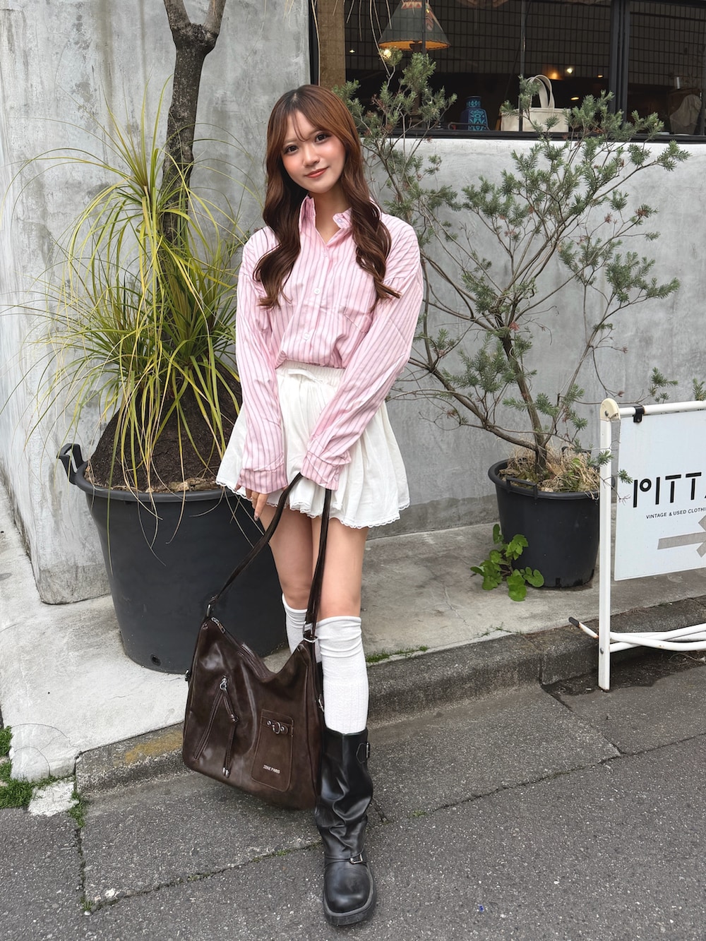 ピンク系のシャツ/ブラウス、ブラウン系のショルダーバッグを着用したレディースの春コーディネートの2枚目の写真