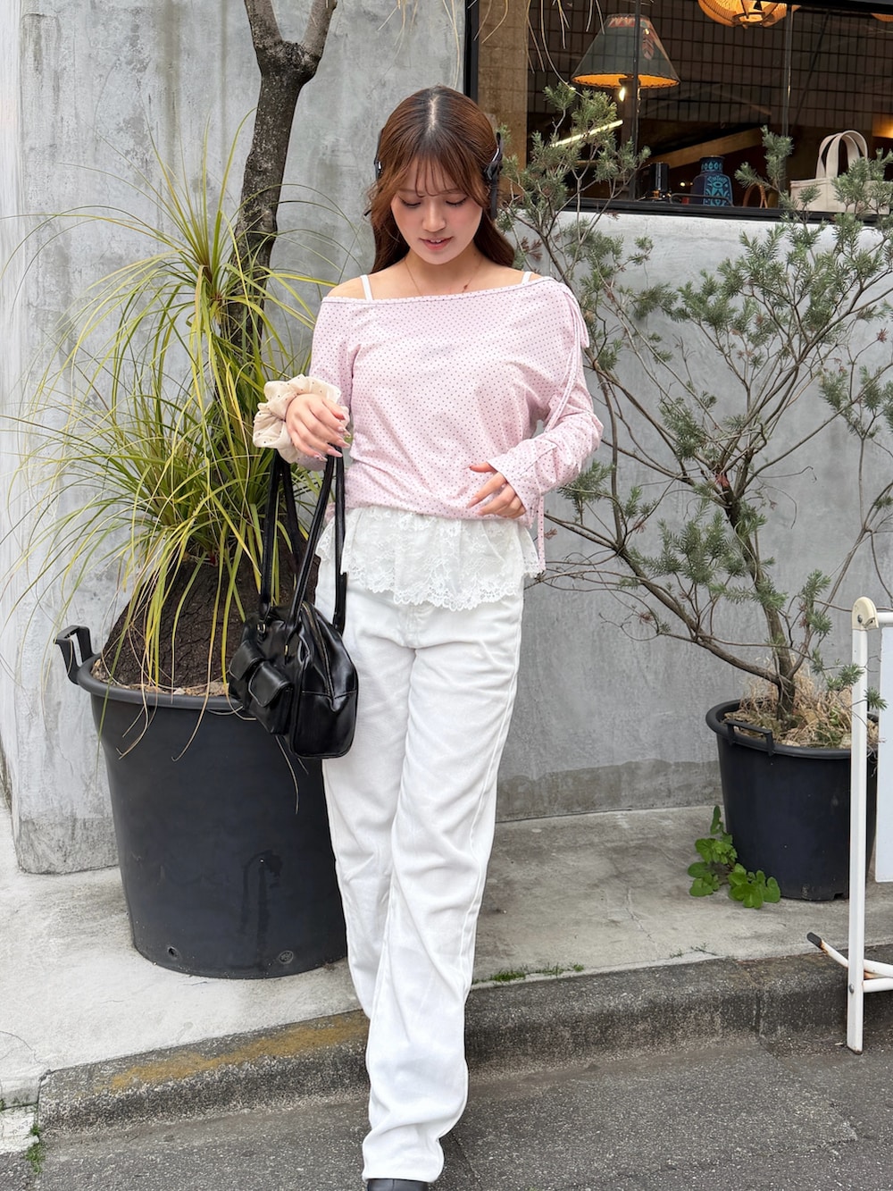 ホワイト系のデニムパンツ、ピンク系のTシャツ/カットソー、ブラック系のボストンバッグを着用したレディースの春コーディネートの2枚目の写真