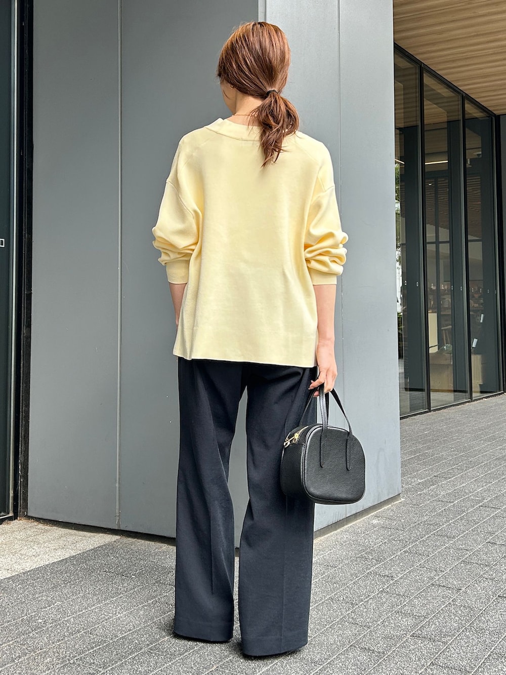ブラック系のその他パンツ、イエロー系のカーディガン/ボレロ、ブラック系のボストンバッグを着用したレディースの春コーディネートの3枚目の写真