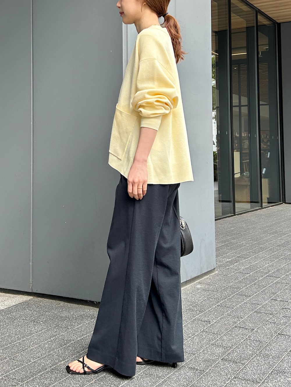 ブラック系のその他パンツ、イエロー系のカーディガン/ボレロ、ブラック系のボストンバッグを着用したレディースの春コーディネートの2枚目の写真