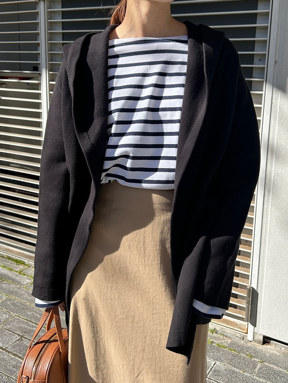 ブラック系のバレエシューズ、ブルー系のTシャツ/カットソー、ブラック系のカーディガン/ボレロを着用したレディースの冬コーディネートの4枚目の写真