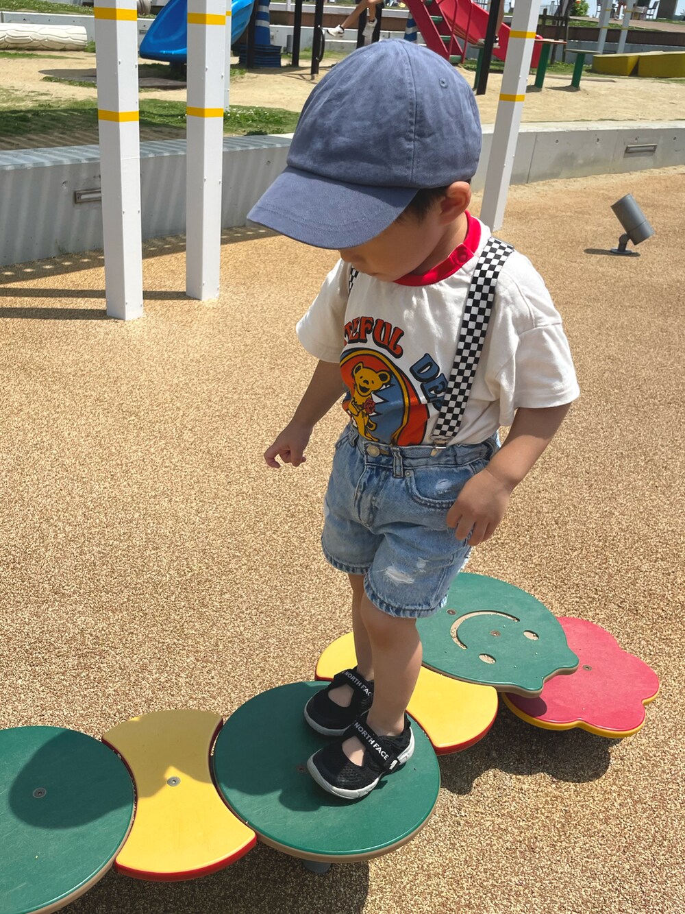 ブルー系のデニムパンツ、ブラック系のサンダル、レッド系のTシャツ/カットソーを着用したキッズの夏コーディネートの4枚目の写真