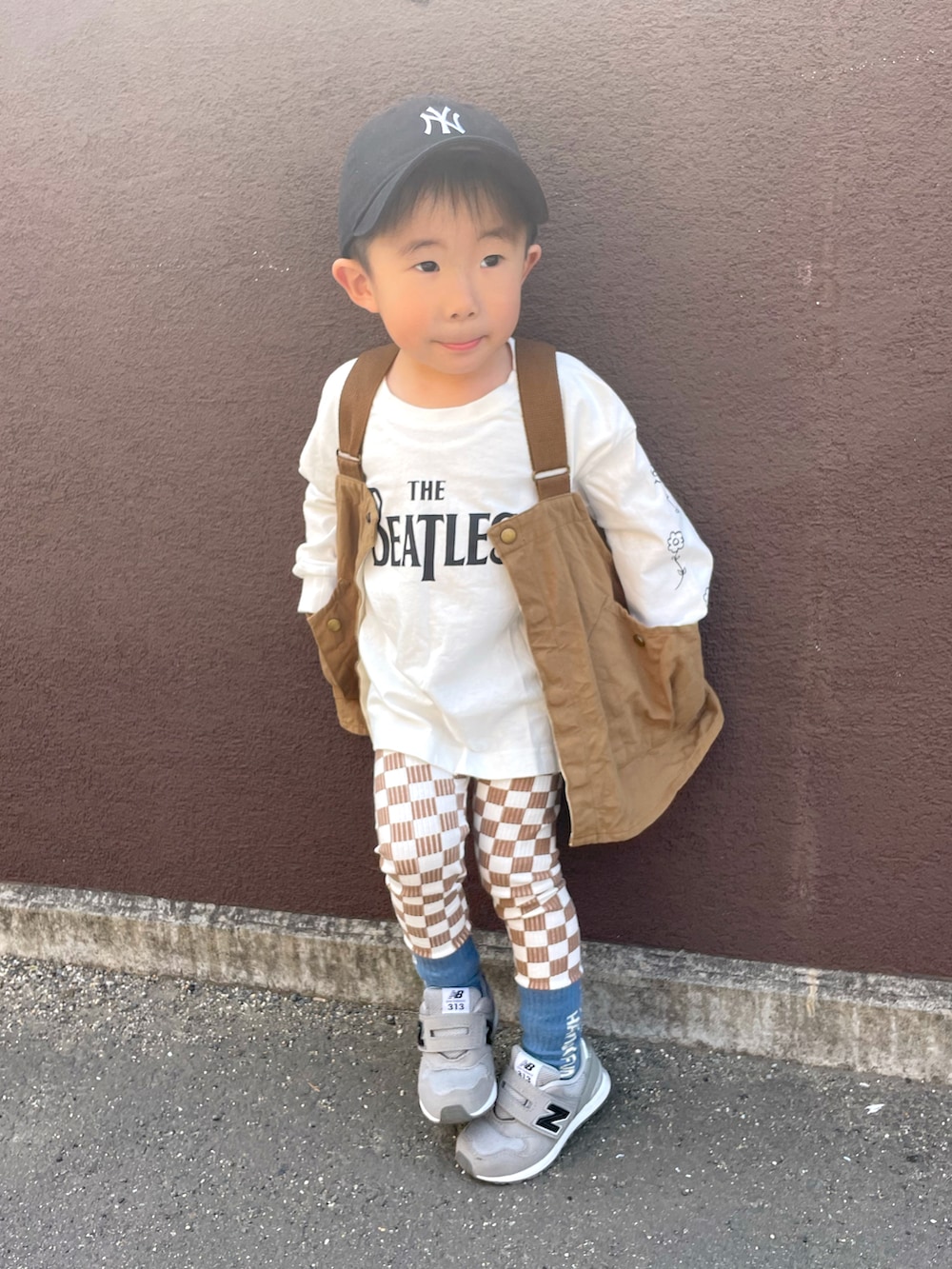 ホワイト系のTシャツ/カットソー、ベージュ系のベスト、グレー系のスニーカーを着用したキッズの春コーディネートの2枚目の写真