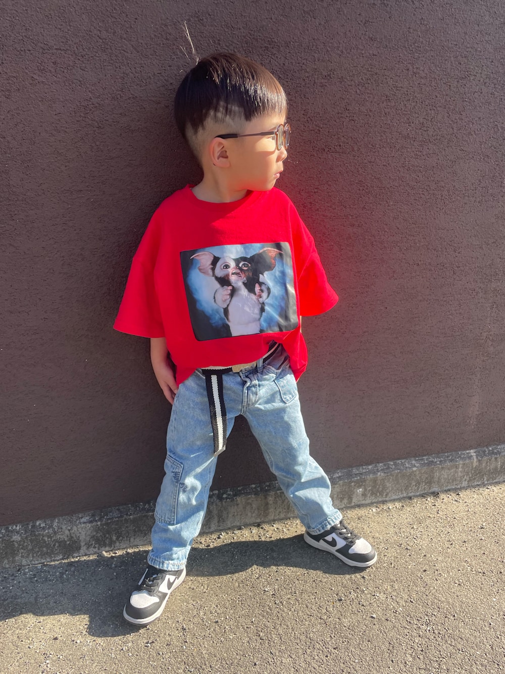 レッド系のTシャツ/カットソー、ブルー系のデニムパンツ、ブラック系のスニーカーを着用したキッズの春コーディネートの3枚目の写真