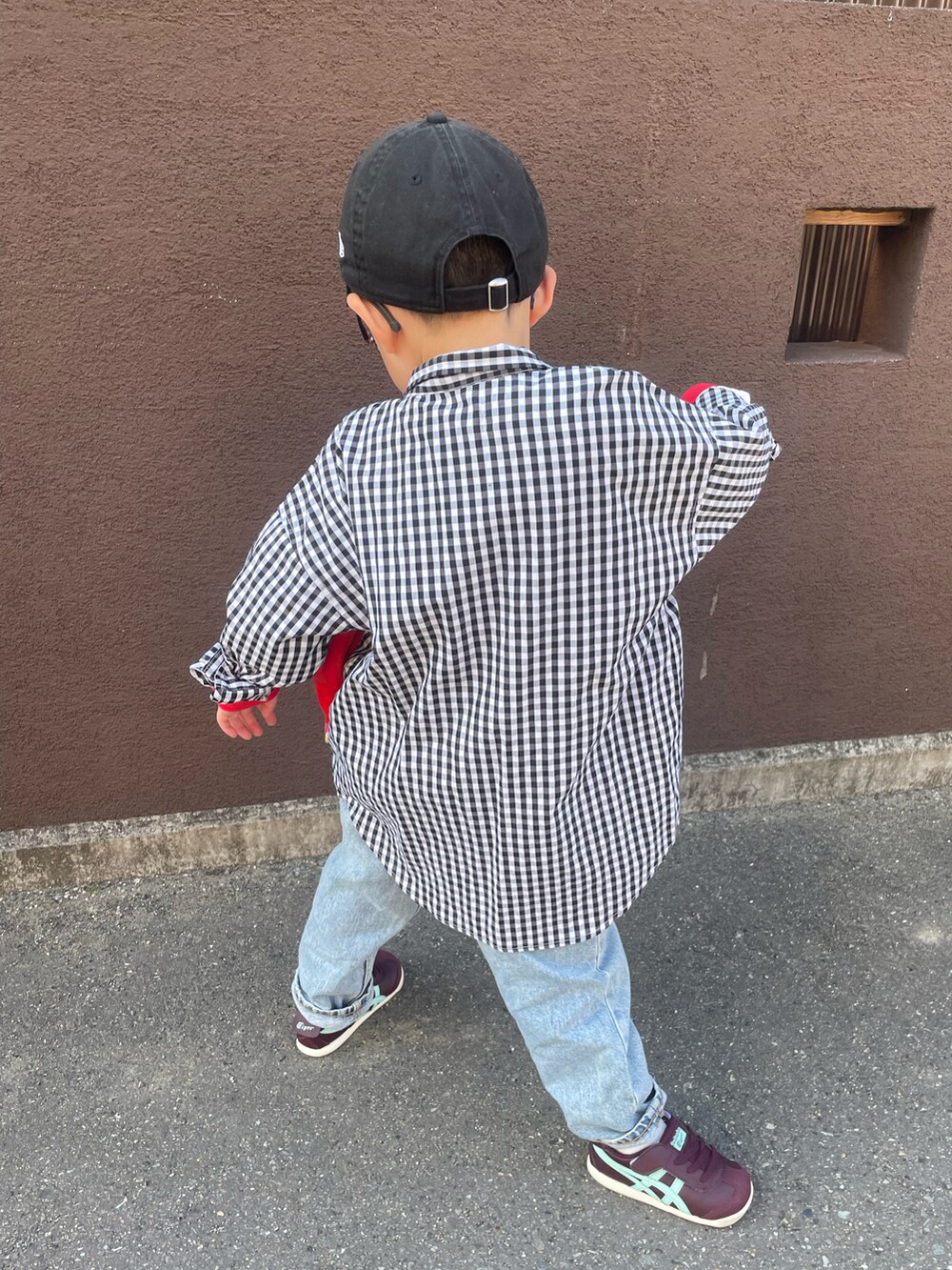 レッド系のTシャツ/カットソー、ブラック系のシャツ/ブラウス、ブルー系のデニムパンツを着用したキッズの春コーディネートの2枚目の写真