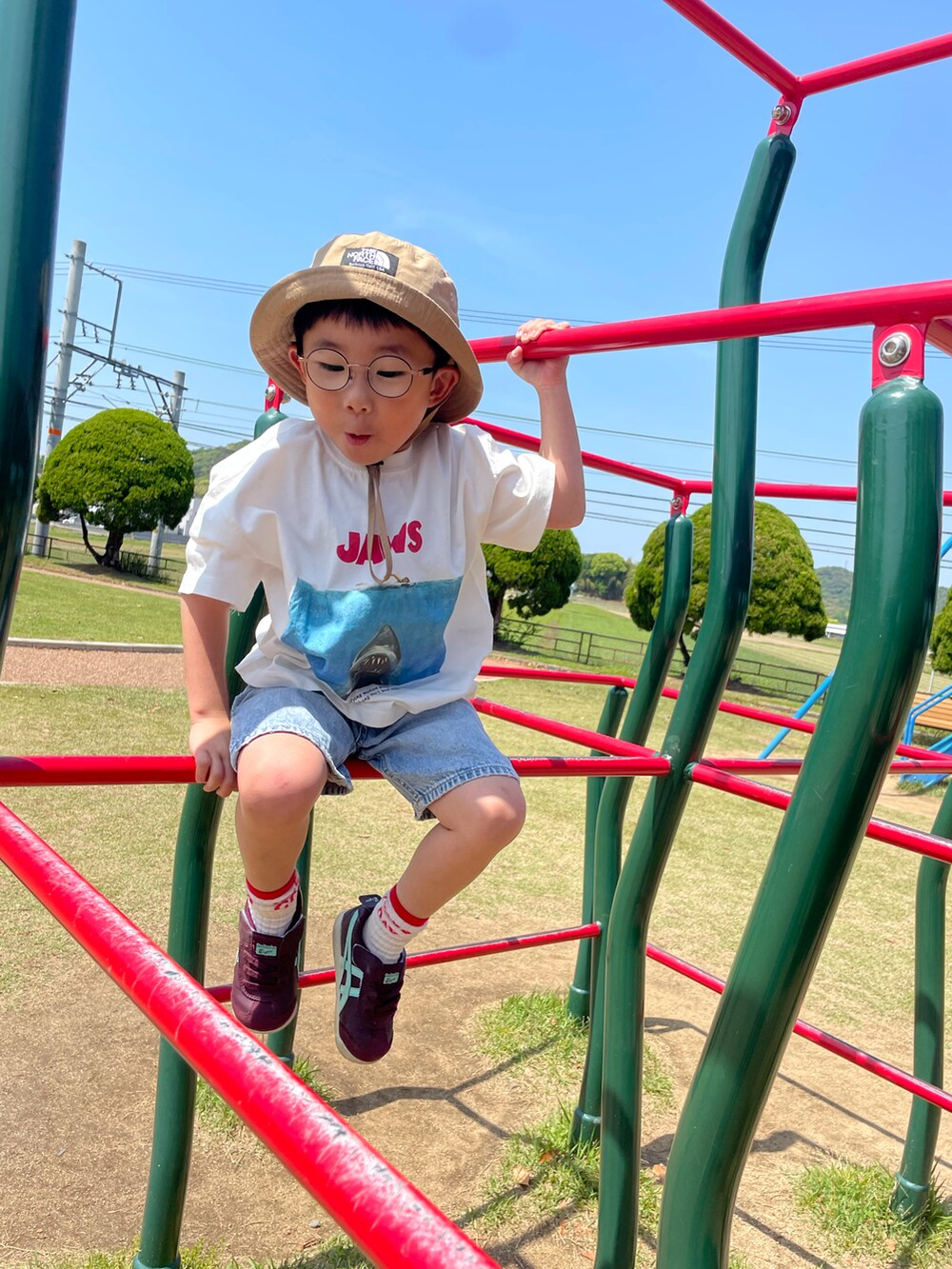 ホワイト系のTシャツ/カットソー、ブルー系のデニムパンツ、レッド系のスニーカーを着用したキッズの春コーディネートの3枚目の写真