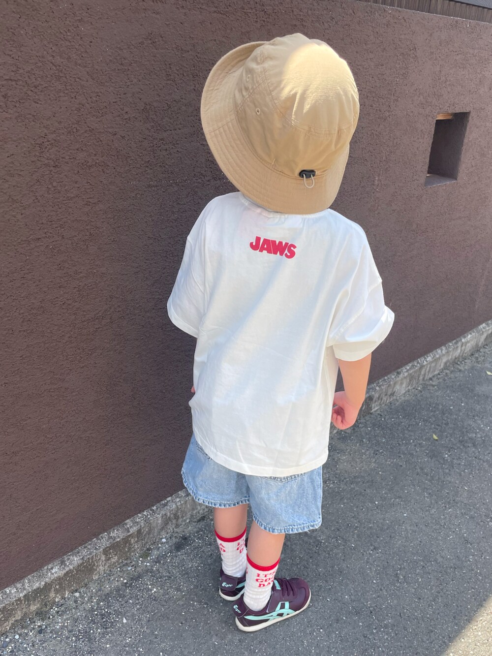 ホワイト系のTシャツ/カットソー、ブルー系のデニムパンツ、レッド系のスニーカーを着用したキッズの春コーディネートの2枚目の写真