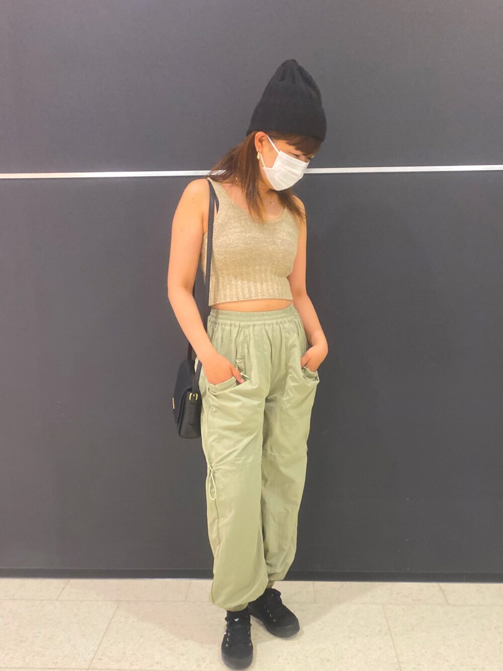 ベージュ系のタンクトップ、ベージュ系のカーディガン/ボレロ、グリーン系のカーゴパンツを着用したレディースの春コーディネートの3枚目の写真