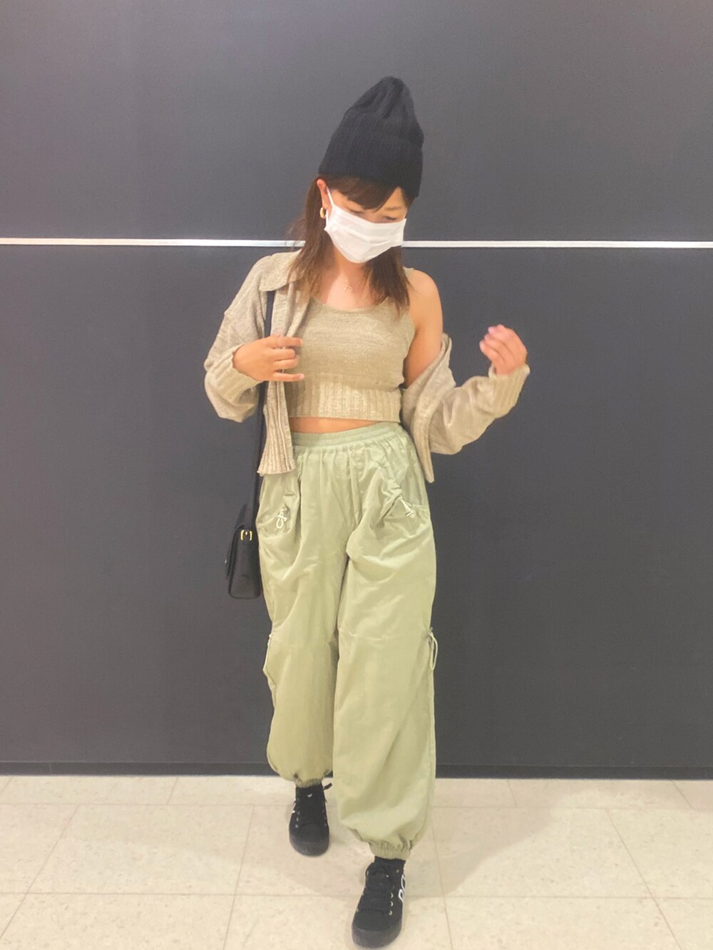 ベージュ系のタンクトップ、ベージュ系のカーディガン/ボレロ、グリーン系のカーゴパンツを着用したレディースの春コーディネートの2枚目の写真