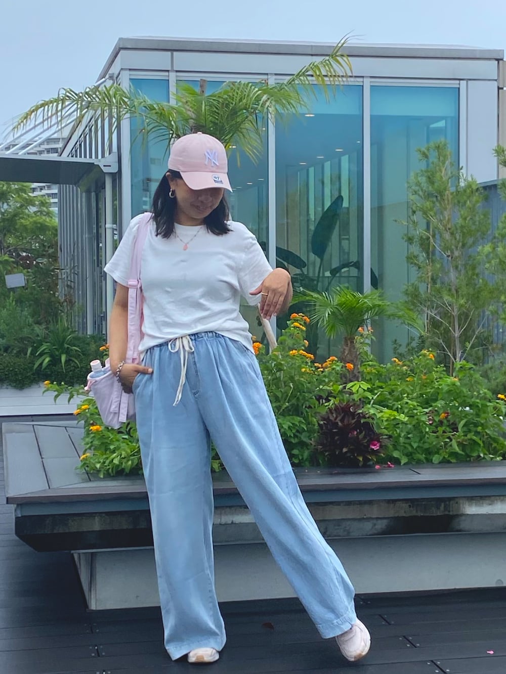 ブルー系のデニムパンツ、ホワイト系のTシャツ/カットソー、ピンク系のスニーカーを着用したレディースの秋コーディネートの4枚目の写真