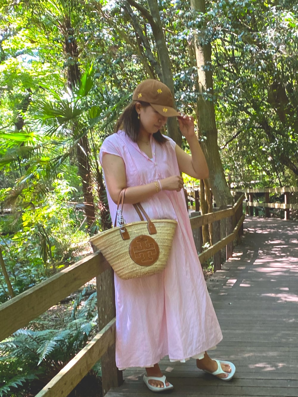 ピンク系のワンピース、ホワイト系のスカート、ブラウン系のかごバッグを着用したレディースの夏コーディネートの2枚目の写真