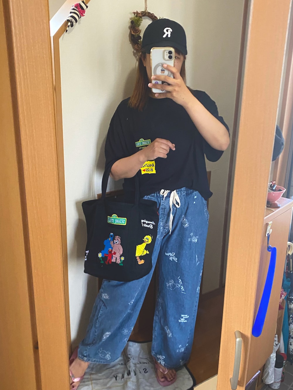 ブラック系のTシャツ/カットソー、ブルー系のパンツ、ブラック系のバッグを着用したレディースの夏コーディネートの2枚目の写真