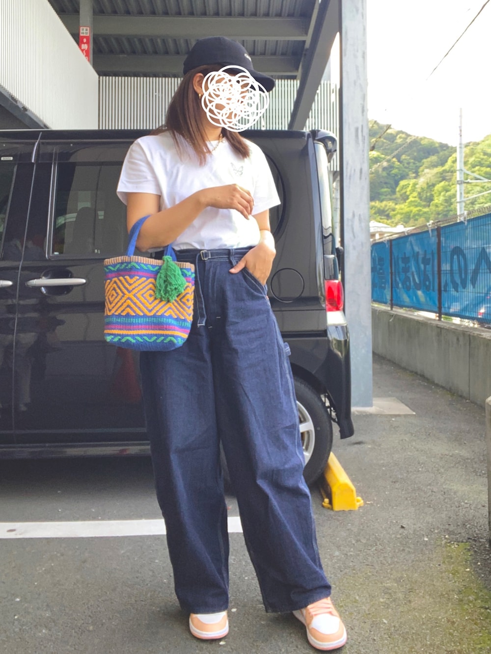 ホワイト系のTシャツ/カットソー、ブルー系のデニムパンツ、ブルー系のハンドバッグを着用したレディースの春コーディネートの2枚目の写真