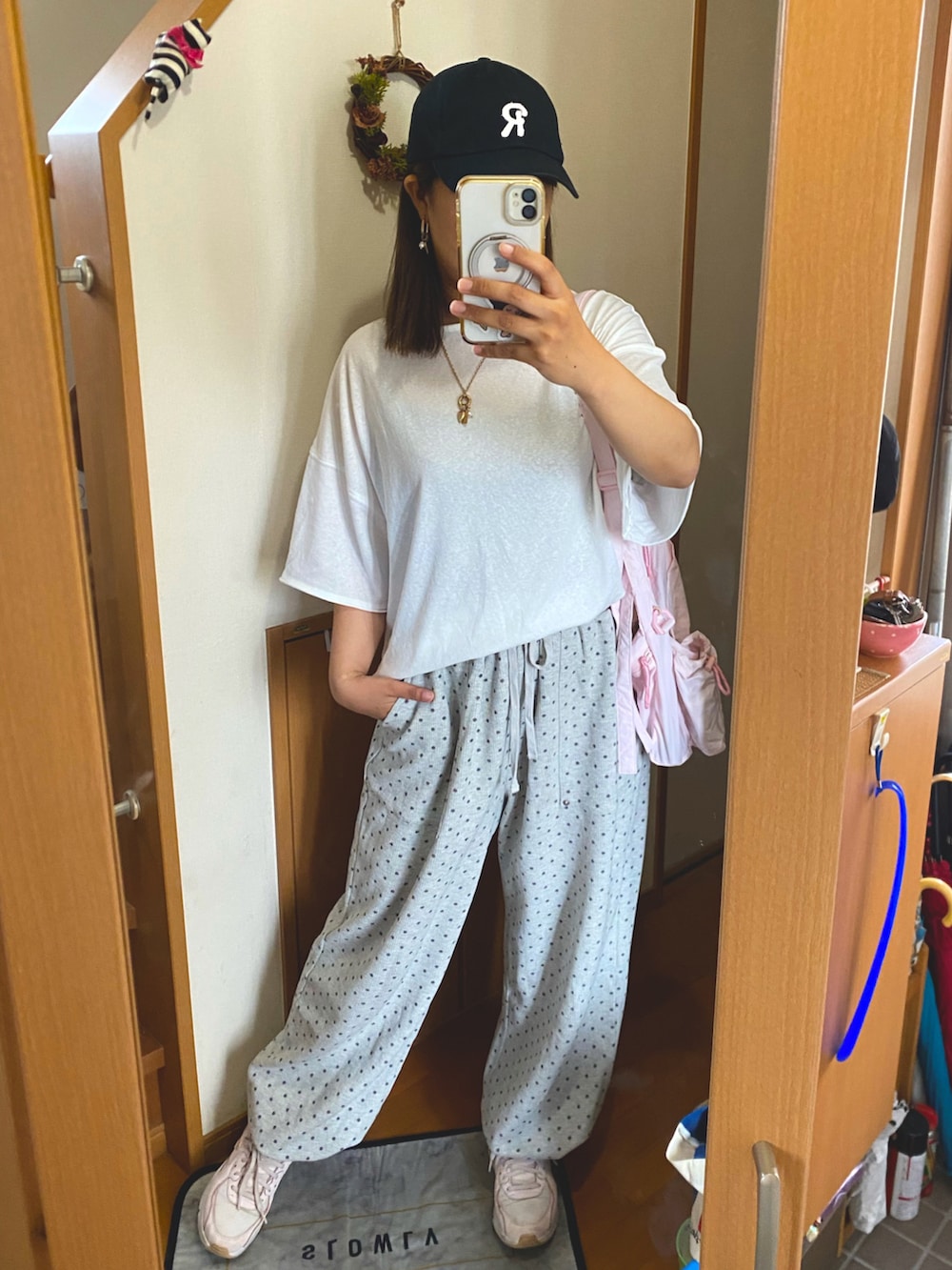 ホワイト系のTシャツ/カットソー、グレー系のスウェットパンツ、ピンク系のショルダーバッグを着用したレディースの秋コーディネートの2枚目の写真
