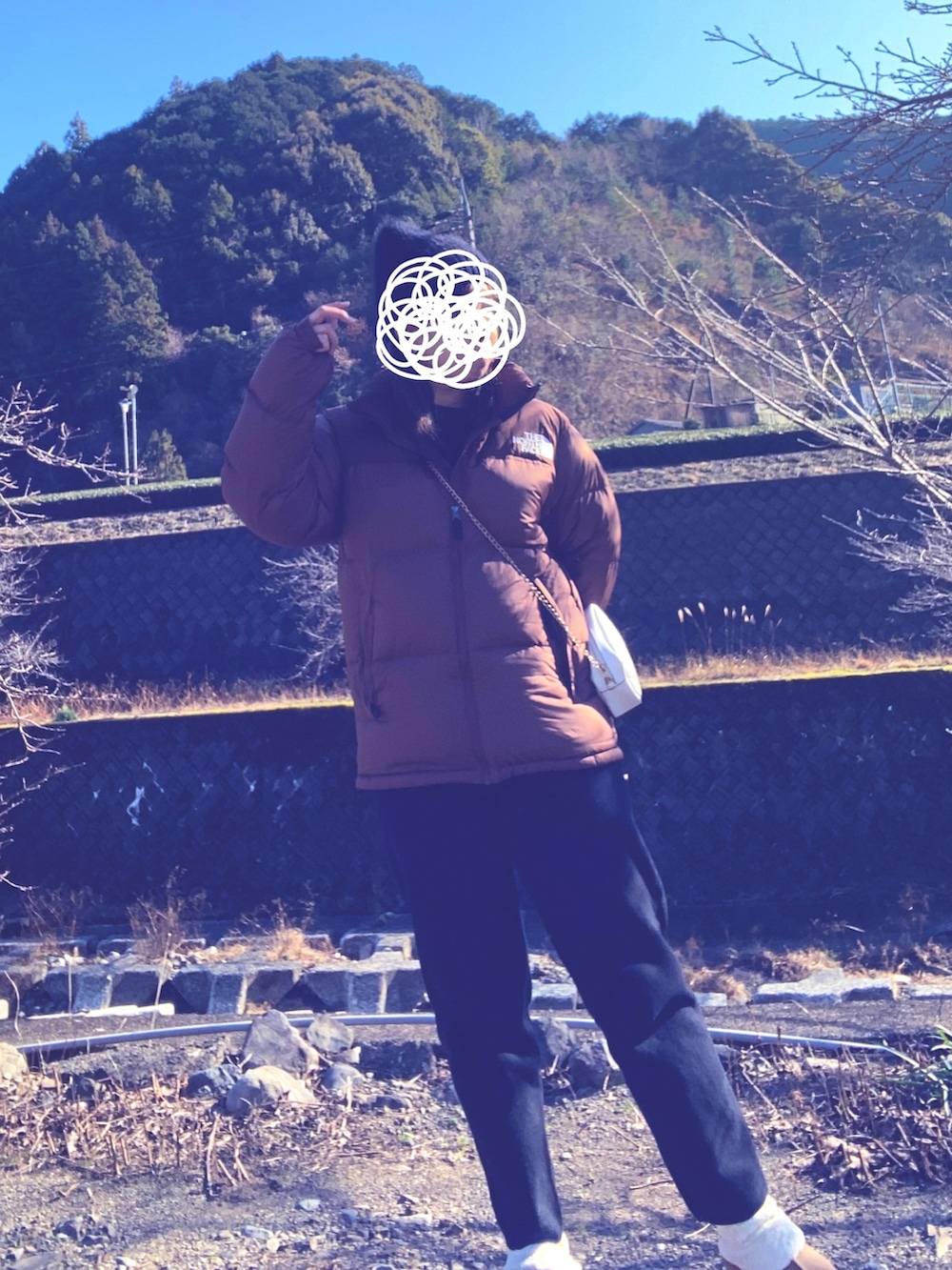 ブラウン系のダウンジャケット/コート、ブラック系のニット/セーター、ブラック系のパンツを着用したレディースの冬コーディネートの2枚目の写真