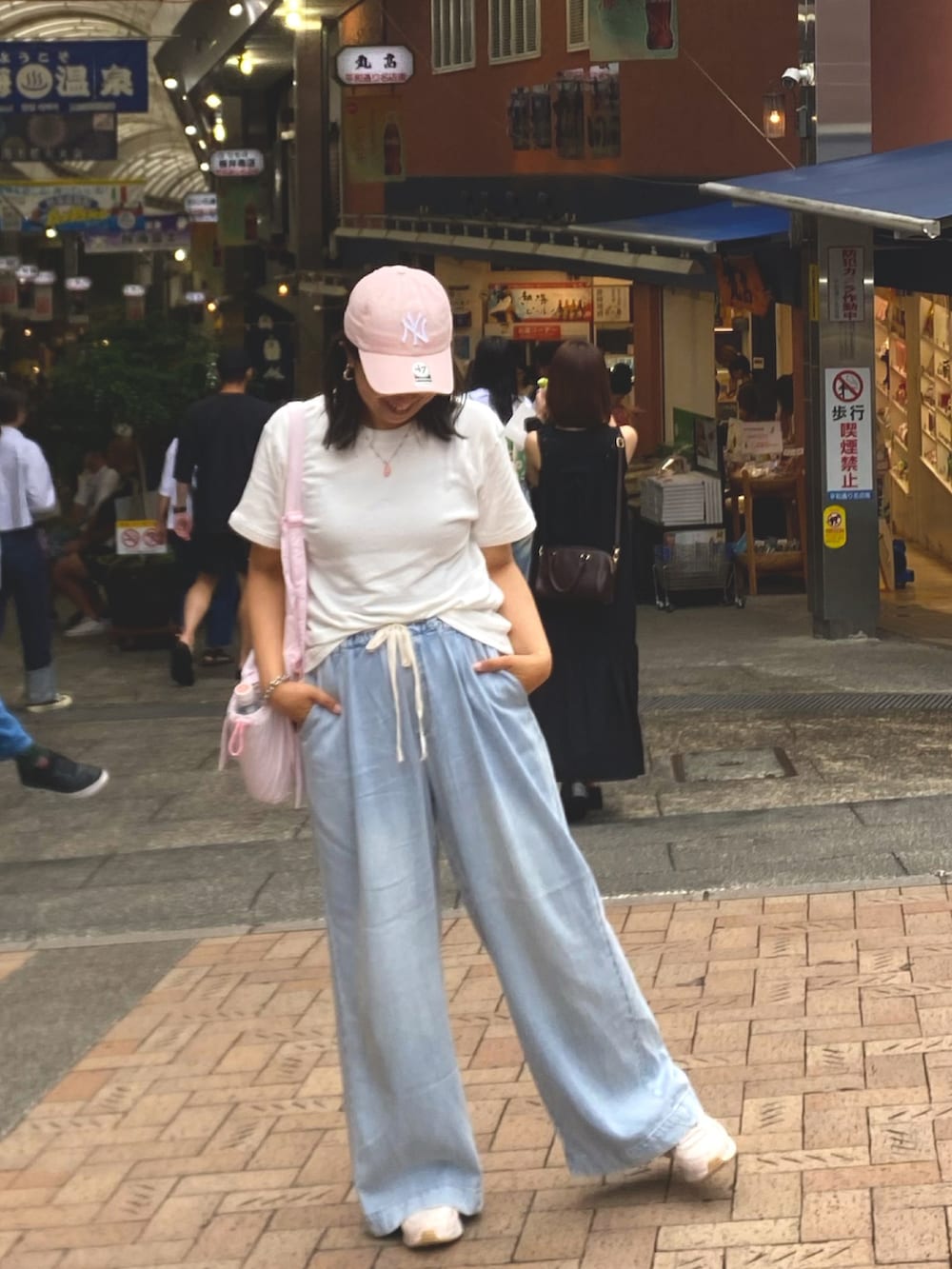 ブルー系のデニムパンツ、ホワイト系のTシャツ/カットソー、ピンク系のスニーカーを着用したレディースの秋コーディネートの5枚目の写真